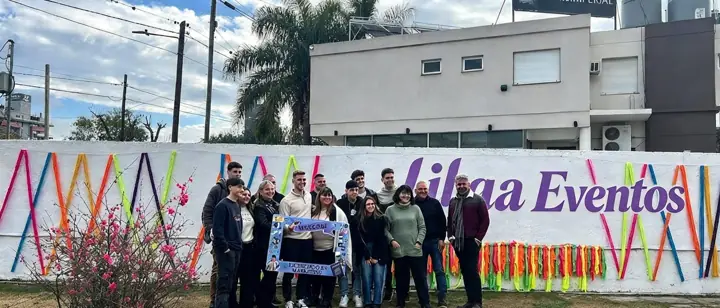Grupo celebrando frente al mural de Lilaa Eventos